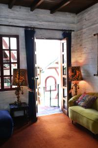 a room with an open door with a green couch at Boutique Hotel Antinea in Quito