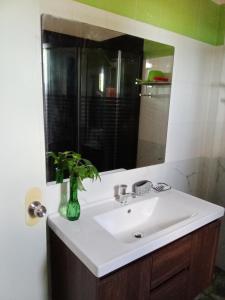 y baño con lavabo blanco y espejo. en Villa Ceferina, en Tagbilaran City