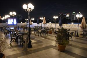 an outdoor patio with tables and chairs and umbrellas at night at Zamalek Army Hotel in Cairo