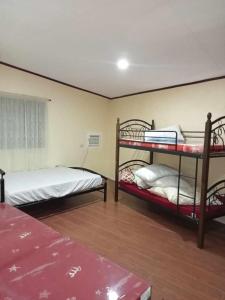 a bedroom with two bunk beds and a window at Villa Ceferina in Tagbilaran City
