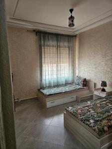 Zimmer mit 2 Betten und einem Fenster in der Unterkunft Green house in Saidia 