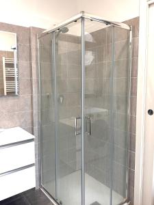 y baño con ducha y puerta de cristal. en Appartamentino Via Trotti, en Cremona