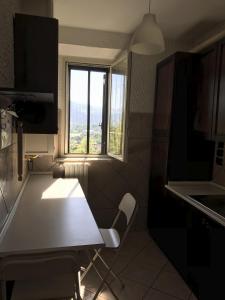 une petite cuisine avec une table et une fenêtre dans l'établissement Casa Campo dei Fiori, à Pontecorvo