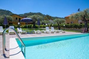 een zwembad met stoelen en parasols in een resort bij Ferienwohnung für 6 Personen ca 75 qm in Cefalù, Sizilien Nordküste von Sizilien - b44294 in Cefalù