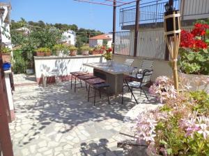 een patio met een tafel, stoelen en bloemen bij Ferienwohnung für 4 Personen ca 60 qm in Pula, Istrien Istrische Riviera in Pula