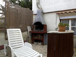een patio met een pizza-oven en 2 witte stoelen bij Ferienwohnung für 4 Personen ca 60 qm in Pula, Istrien Istrische Riviera in Pula