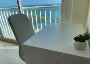 einen weißen Tisch und einen Stuhl mit Meerblick in der Unterkunft Santo Domingo DN La Julia in Santo Domingo