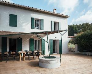 a house with a patio with a table and chairs at Villavos- Le Bocage in Cassis