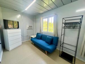a living room with a blue couch and a shelf at Grace Container homes in Cedar Grove