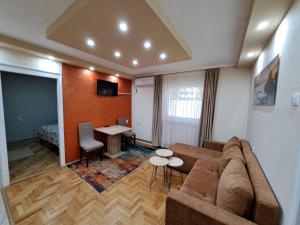 a living room with a couch and a table at Apartman Borsalino Subotica in Subotica