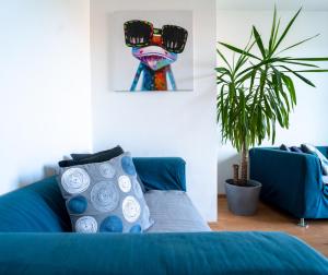a room with a blue couch and a painting of a frog at Viola Apartment in Budapest