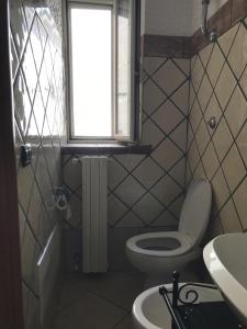 La salle de bains est pourvue de toilettes, d'un lavabo et d'une fenêtre. dans l'établissement Casa Campo dei Fiori, à Pontecorvo