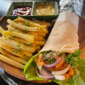 a plate of food with a sandwich and french fries at Mojo Hostel in Puerto Princesa City