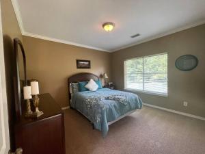 1 dormitorio con 1 cama con edredón azul y ventana en Prancing Horse Estates- 10 acres w/huge pool + spa, en Montgomery