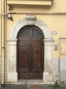 une grande porte en bois dans un bâtiment avec une arche dans l'établissement Casa Campo dei Fiori, à Pontecorvo