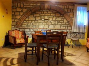 una mesa y sillas en una habitación con una pared de ladrillo en La Taverna en Morcone