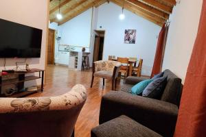 - un salon avec deux canapés et une télévision à écran plat dans l'établissement Cabaña descanso naturaleza, à Colbún