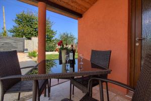 a patio table with two chairs and a bottle of wine at Ferienhaus mit Privatpool für 5 Personen ca 80 qm in Loborika, Istrien Südküste von Istrien in Loborika