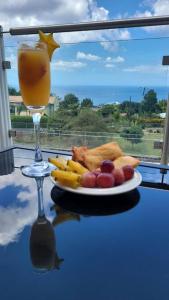 een bord eten op een tafel met een glas sinaasappelsap bij Château Charles, Coubaril, stunning Ocean view a 12 min drive to Vigie Beach in Castries