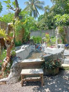 een tuin met een bank, een tafel en een boom bij ATB Hostel in Lovina