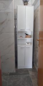 a white cabinet in a bathroom with a shower at Piccolo in Knin
