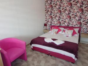 a bedroom with a pink bed and a pink chair at Noclegi-SKAŁKA in Olsztyn