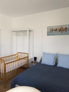 1 dormitorio con 1 cama y 1 cuna en Les Jolis Nids - Studio Rouge Gorge, en La Roche-Posay