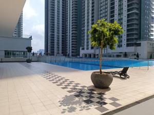 a tree in a pot in a courtyard with tall buildings at Razak City Centre KL SkyView 45th in Kuala Lumpur