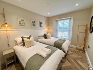 a bedroom with two beds with white and green at Number 8 Croft House in Pembrokeshire