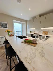 una cocina con una barra con copas de vino. en Number 8 Croft House Tenby, en Tenby