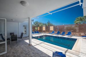 a swimming pool in a house with chairs around it at Ferienhaus mit Privatpool für 8 Personen ca 160 qm in Agia Napa, Südküste von Zypern in Ayia Napa