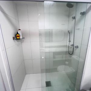 eine Dusche mit Glastür im Bad in der Unterkunft Studio maravilhoso PUC in Porto Alegre