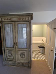 a bathroom with a toilet and a wooden cabinet at Old Manor House in Shepperton