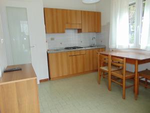 uma cozinha com armários de madeira e uma mesa de madeira em Villa ANNA 3 em Lignano Sabbiadoro