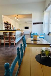 un restaurante con mesas, sillas y una barra en Ubytování Ostende - penzion, en Chocerady