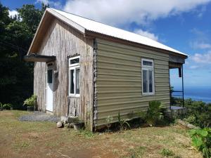 un pequeño edificio de madera en lo alto de un campo en Lovers View, en Giraudel