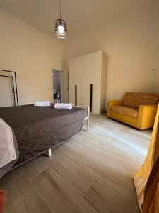 a bedroom with a bed and a couch at Casa vacanza Sofiu' in Mazara del Vallo