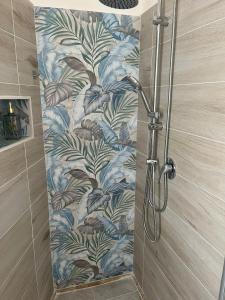 a shower stall with a blue and green wallpaper at Casa vacanza Sofiu' in Mazara del Vallo +26 photos