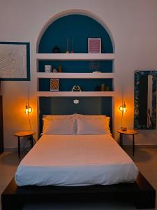 1 Schlafzimmer mit einem Bett mit blauem Kopfteil und 2 Lampen in der Unterkunft Caligo in La Spezia