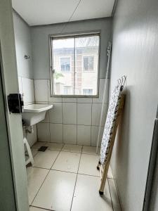 a bathroom with a sink and a window at Compacto e bem localizado in Rio Verde