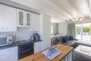 cocina y sala de estar con sofá y mesa en A Resort Gem With A Pool en Cape St Francis