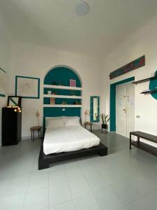 Schlafzimmer mit einem Bett mit blauem Kopfteil in der Unterkunft Caligo in La Spezia