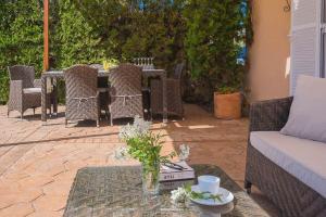 un patio avec une table et des chaises et une table avec un vase dans l'établissement Ferienhaus mit Privatpool für 6 Personen ca 120 m in Sa Rapita, Balearen Mallorca, à Sa Ràpita