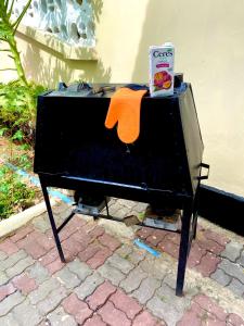 a black piano with an orange towel on it at A private self contained room in a home away from home in Dar es Salaam