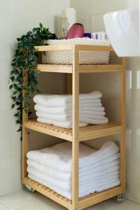 a wooden shelf filled with towels in a bathroom at Elegant Apt 50meters Close Acropolis in Athens