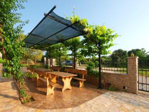 una mesa de picnic y bancos bajo un paraguas solar en Ferienwohnung für 4 Personen ca 48 qm in Medulin, Istrien Südküste von Istrien - b60940, en Medulin