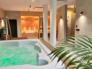 a jacuzzi tub in a room with a plant at SILVER BALTIC in Kołobrzeg