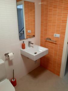 ein Badezimmer mit einem Waschbecken, einem Spiegel und einem WC in der Unterkunft Apartamento Luna con terraza y vistas al mar in Playa