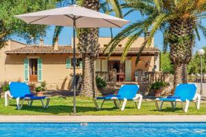 a pair of chairs and an umbrella next to a pool at Haus mit Pool auf Mallorca in Manacor