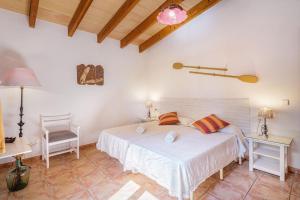 a bedroom with a white bed and a chair at Haus mit Pool auf Mallorca in Manacor